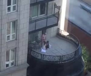 En el balcon de un hotel un viejo con dos putas chupandole polla a la vez y unos vecinos del edificio de enfrente les pilla y le graba.